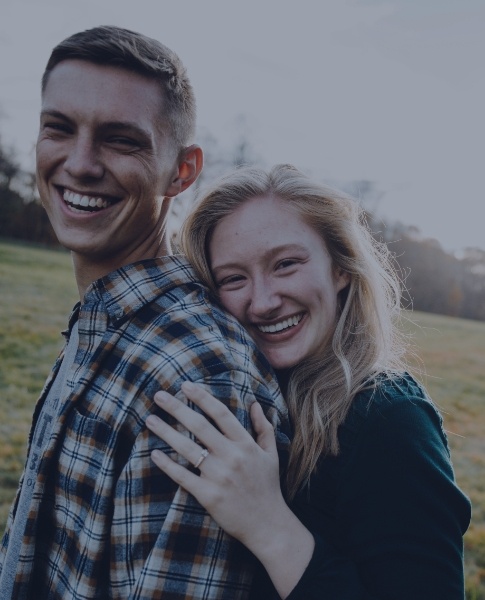Man and woman smiling after emergency dentistry